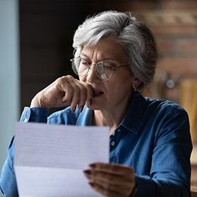 Woman reading a piece of paper, or a bill.