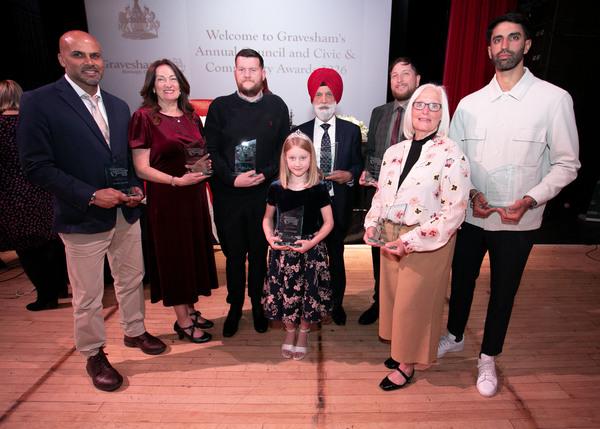 Group of people standing holding their glass community awards