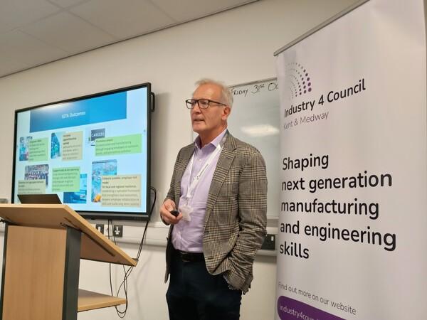 Man standing Infront of board and TV