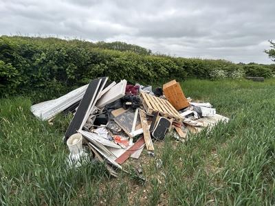 Pile of fly-tipped waste from a household in a field
