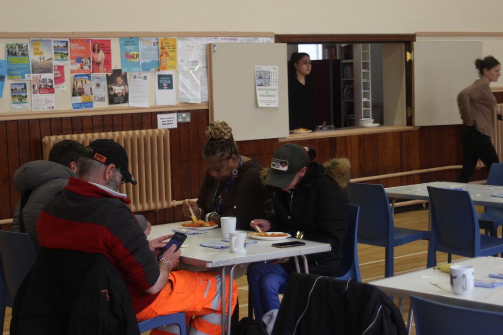 People sitting and eating at the homeless social group