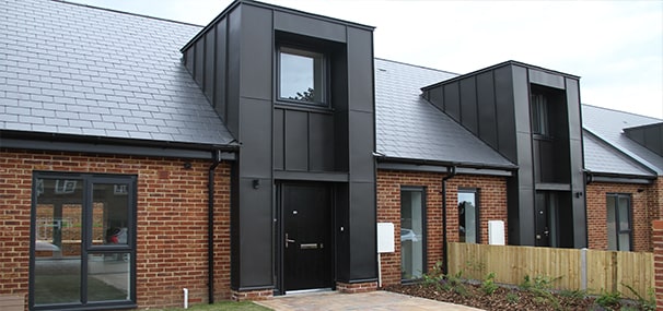 Front of newly built home showing sloped roof, windows and front door