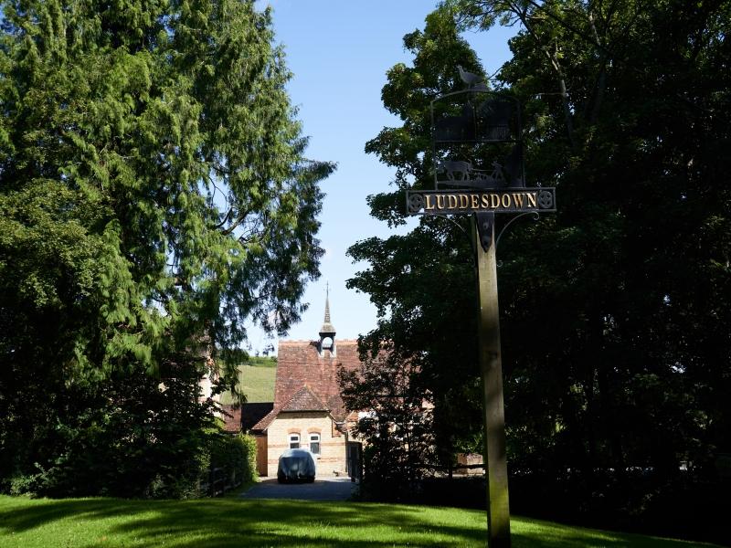Luddesdown sign, green grass outside a building