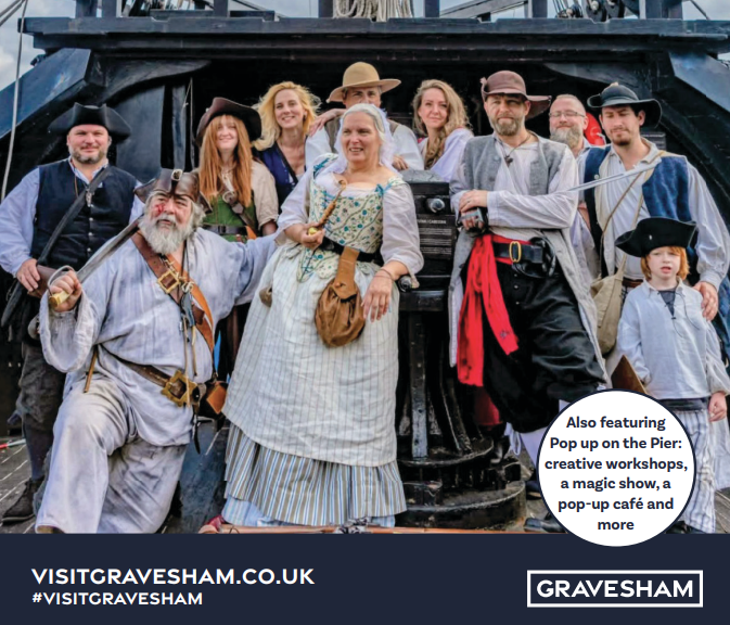 Group of people gathered on deck of a ship dressed in pirate costume.