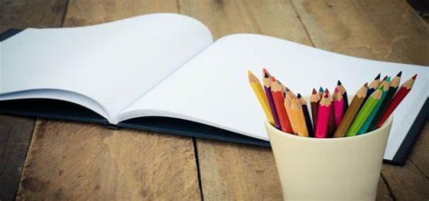 Pot of colourful pencils with blank piece of white paper