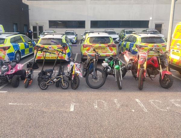Line of seized electric vehicles in a car park behind several police vehicles