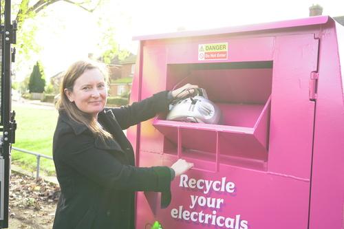 Cllr Emma Morely disposing of waste into the pink electrical recycling bank. 