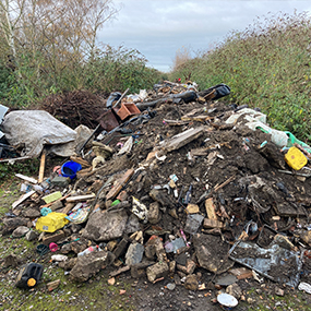pile of fly-tipped rubbish on field