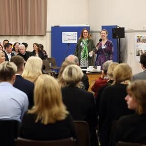 Crowd of people sitting facing someone talking at an event