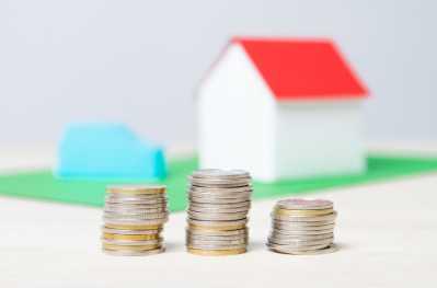 house with stacked coins in front