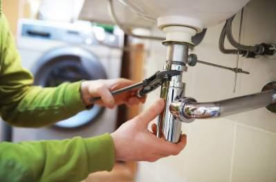 Plumber under the sink fixing a leak